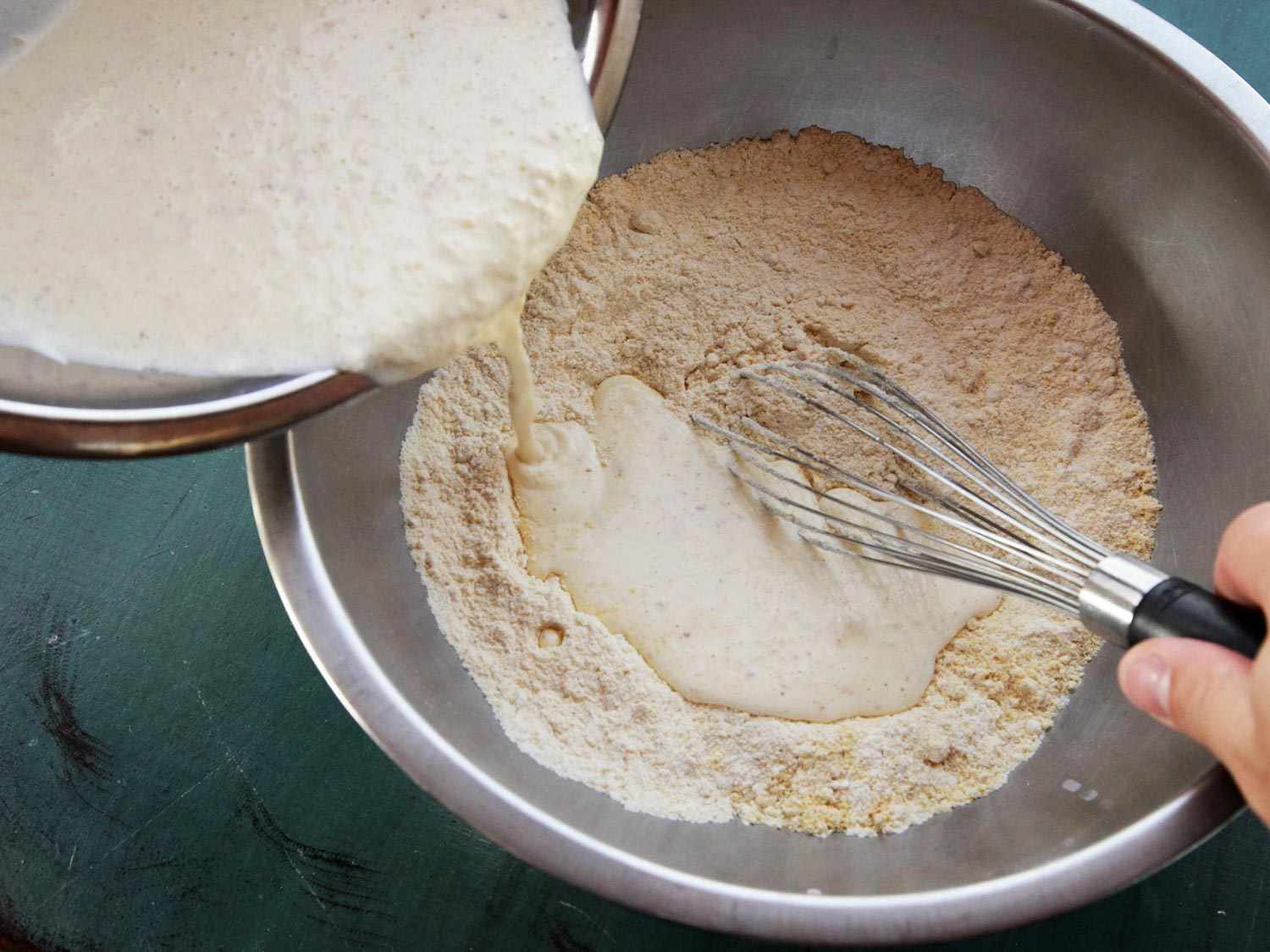 Adding wet ingredients to dry ingredients for browned butter cornbread.