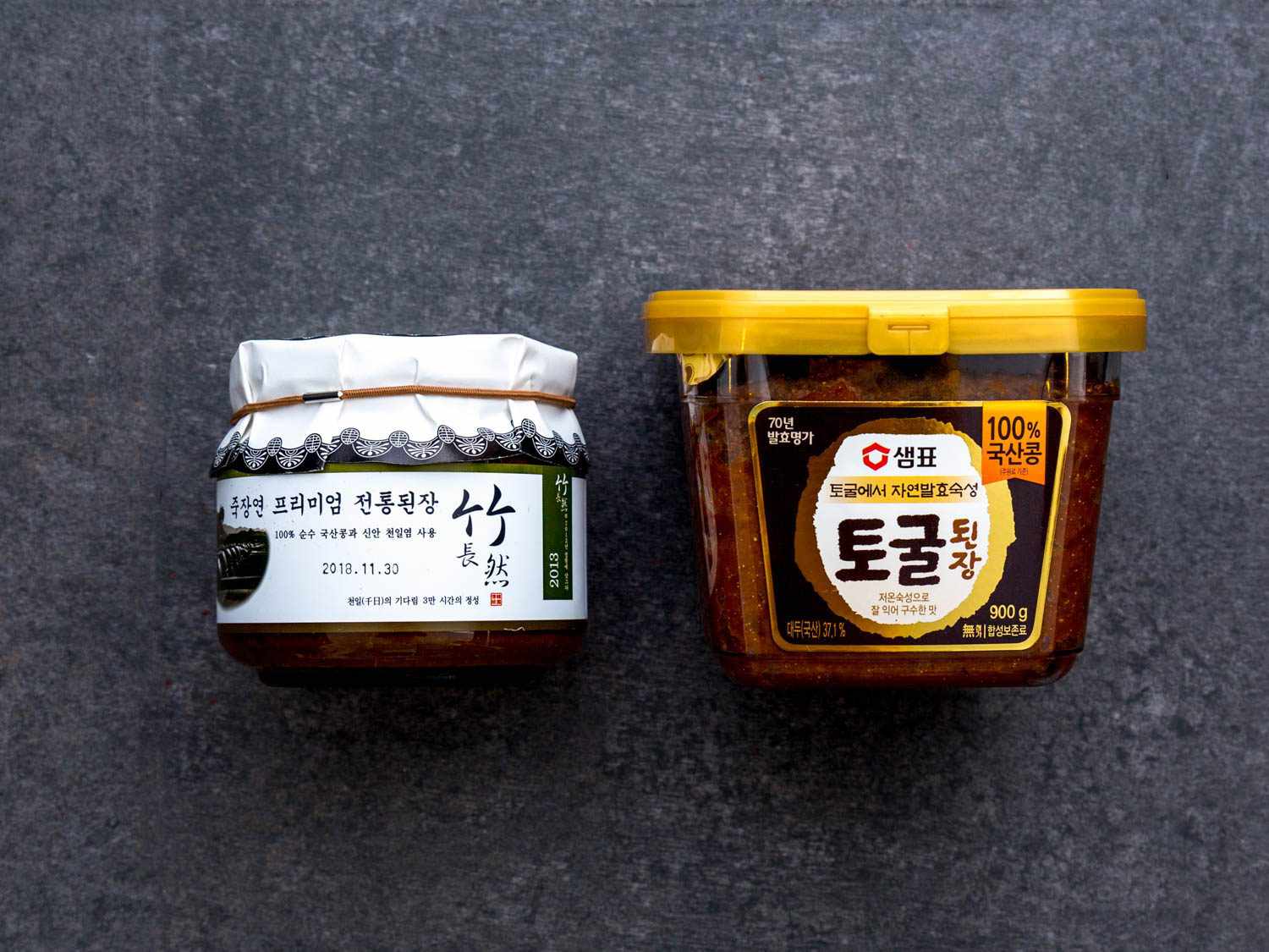Two varieties of doenjang. One is artisanal, traditionally fermented, and aged. The other is a mass-produced product.