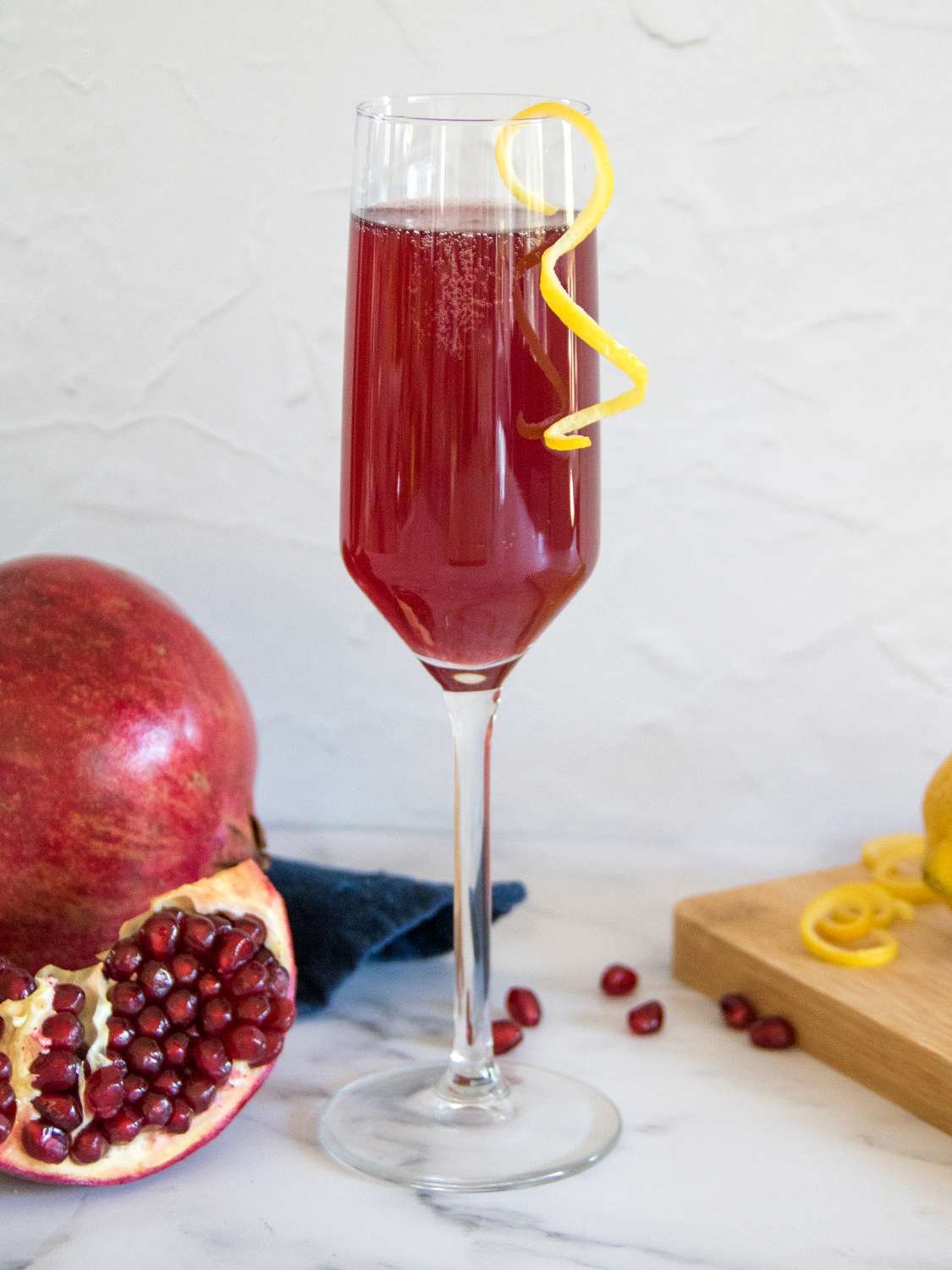 A single Champagne flute garnished with a lemon twist.