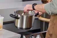 A person stirring the contents of the T-Fal Clipso Pressure Cooker