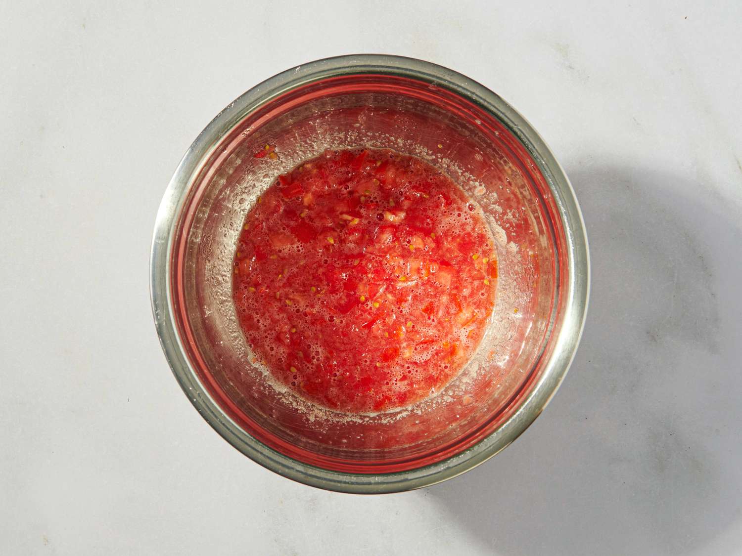 A metal bowl containing a mixture of diced ingredients likely the preparation of a recipe