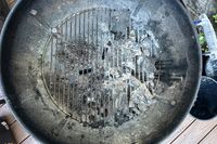 Top view of a barbecue grill withRoyal Oak All Natural Hardwood Lump Charcoal remains and ash on its grate