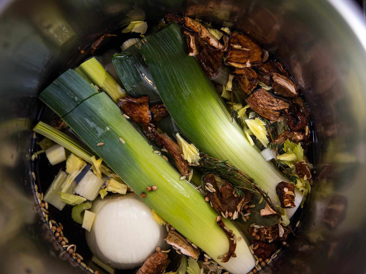 Overhead shot of pot filled with leeks and other ingredients for vegan broth