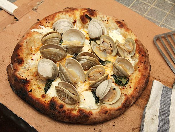 A white sauce pizza topped with steamed clams in their shells.