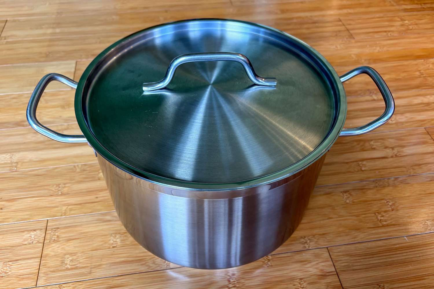 The Vigor stainless steel stockpot on a wooden countertop.