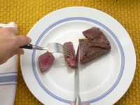 a person cutting a steak with the messermeister knife
