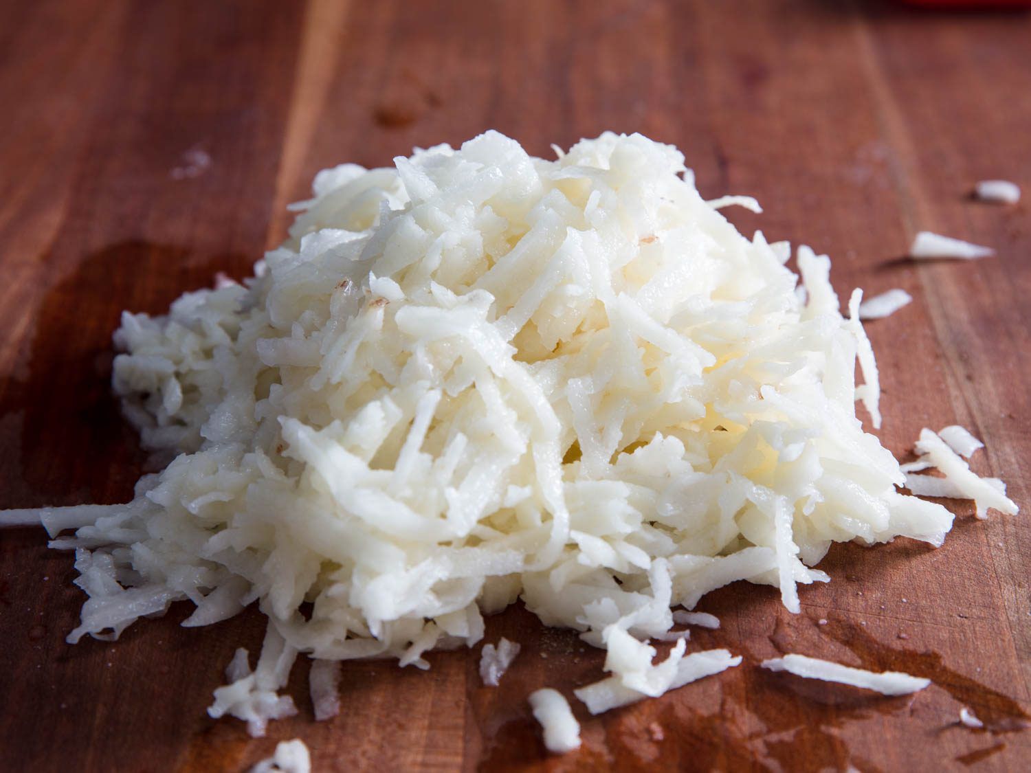 A pile of grated potato on a wooden surface