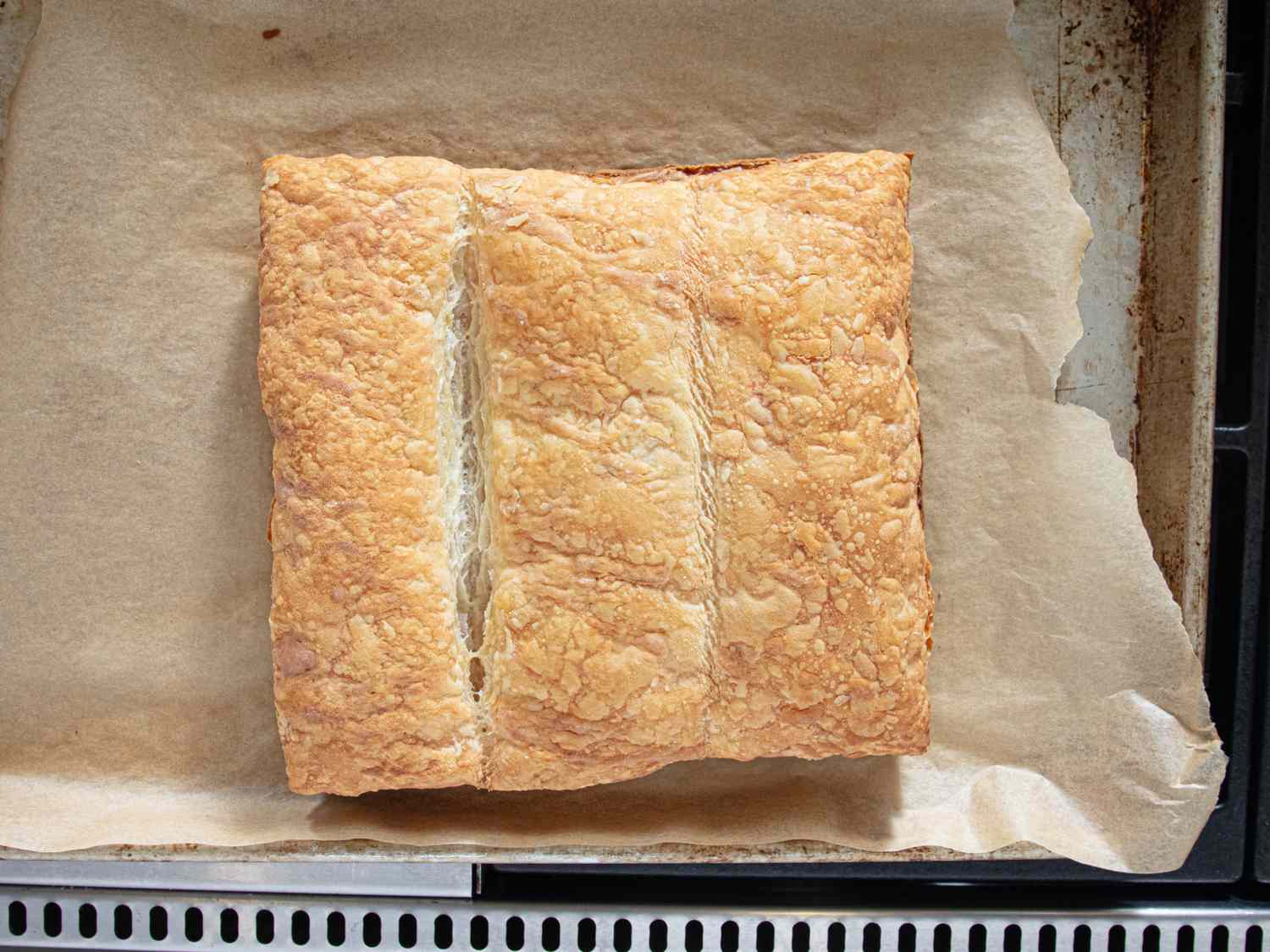 A baked puff pastry square on a parchment paperlined baking tray