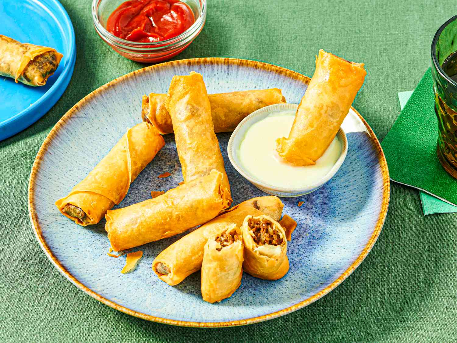 Side view of dipping a cheesesteak egg roll. in cheese