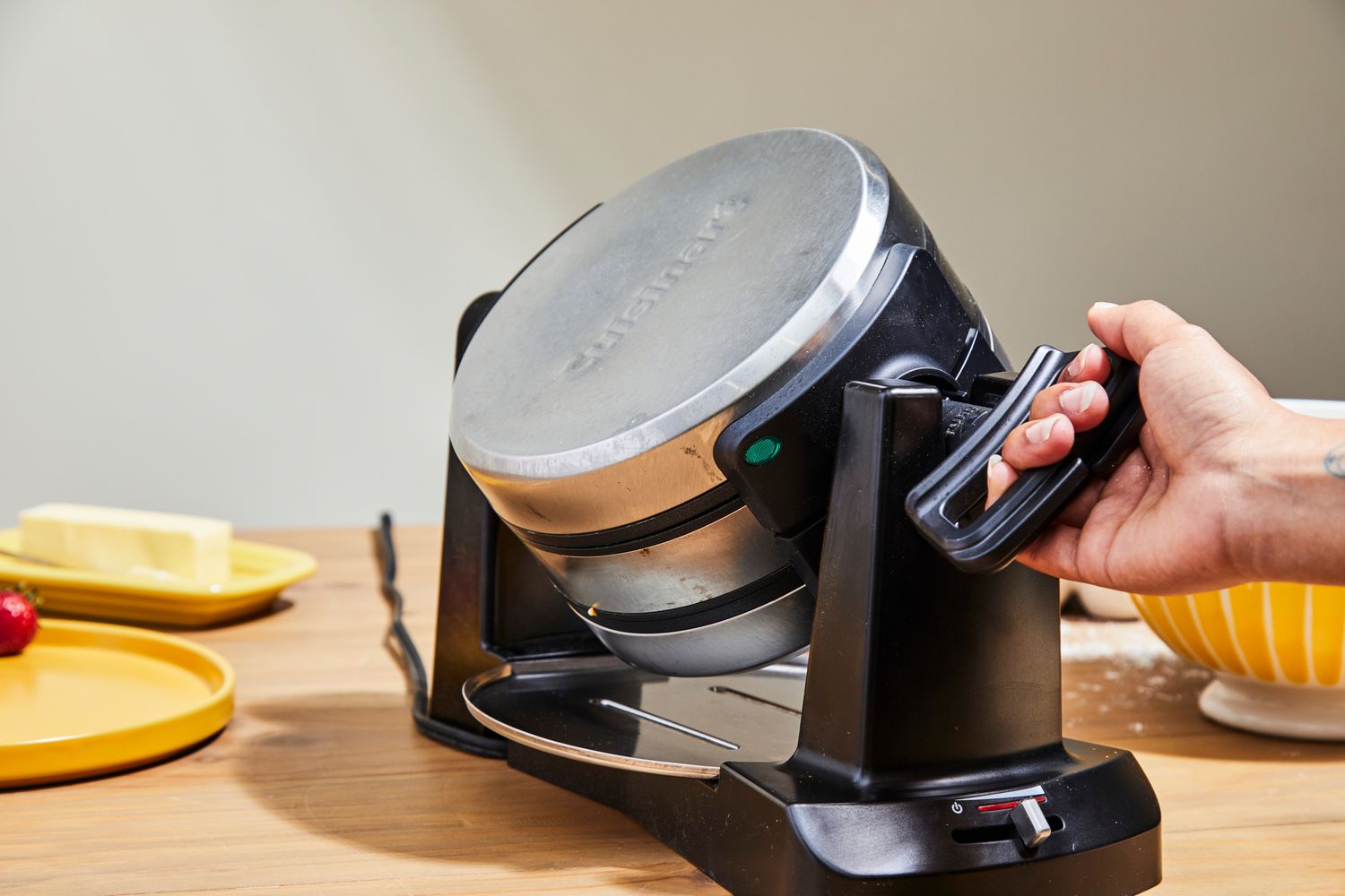 A Belgian waffle maker being flipped on its side.