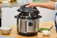 A person removes the lid on the Instant Pot Duo Plus 6-Quart 9-in-1 Pressure Cooker