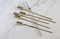 The OXO stainless steel skewers on a kitchen countertop.