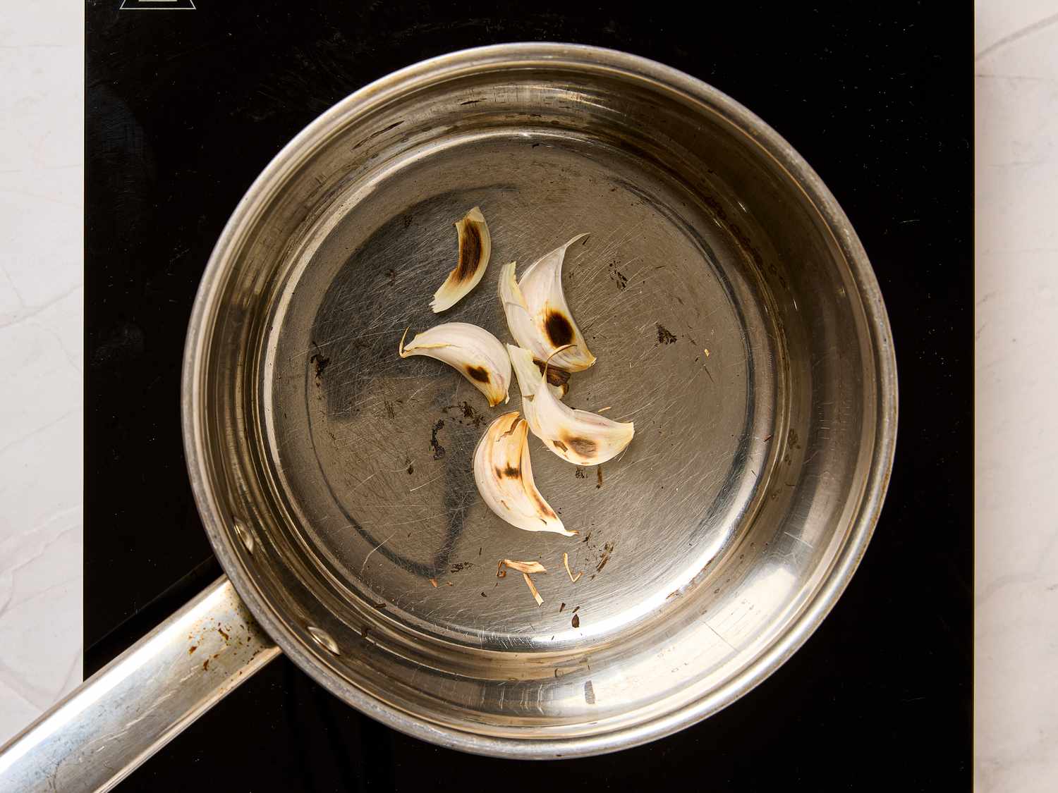 Garlic slices in a saucepan on a stovetop