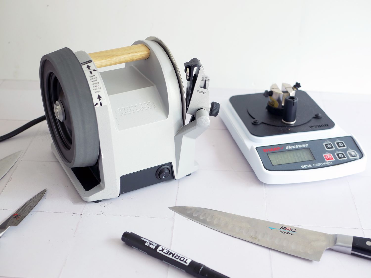 a knife sharpness reader next to the tormek knife sharpener and three knives