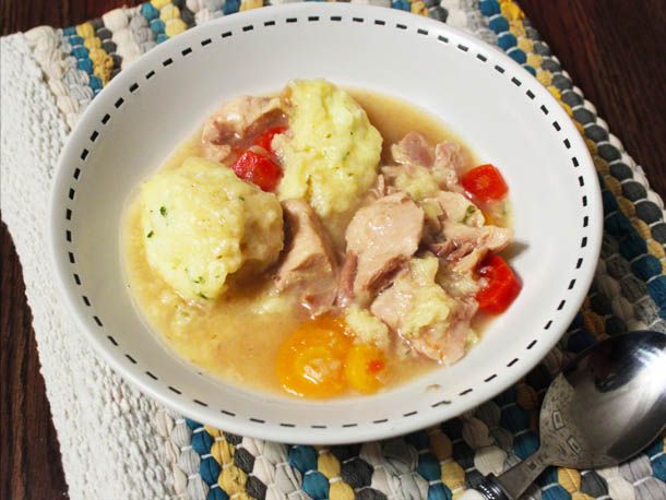 Overhead view of gluten-free chicken and dumplings, served in a shallow white bowl.