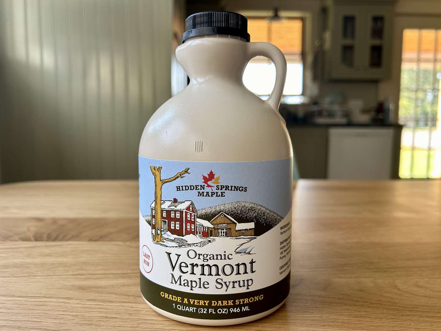 A bottle of Hidden Springs Maple maple syrup on a kitchen table