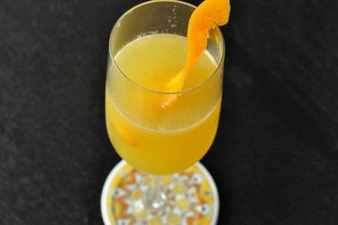 A Cara-Carry Me Away cocktail, served in a stemware glass with an orange twist.