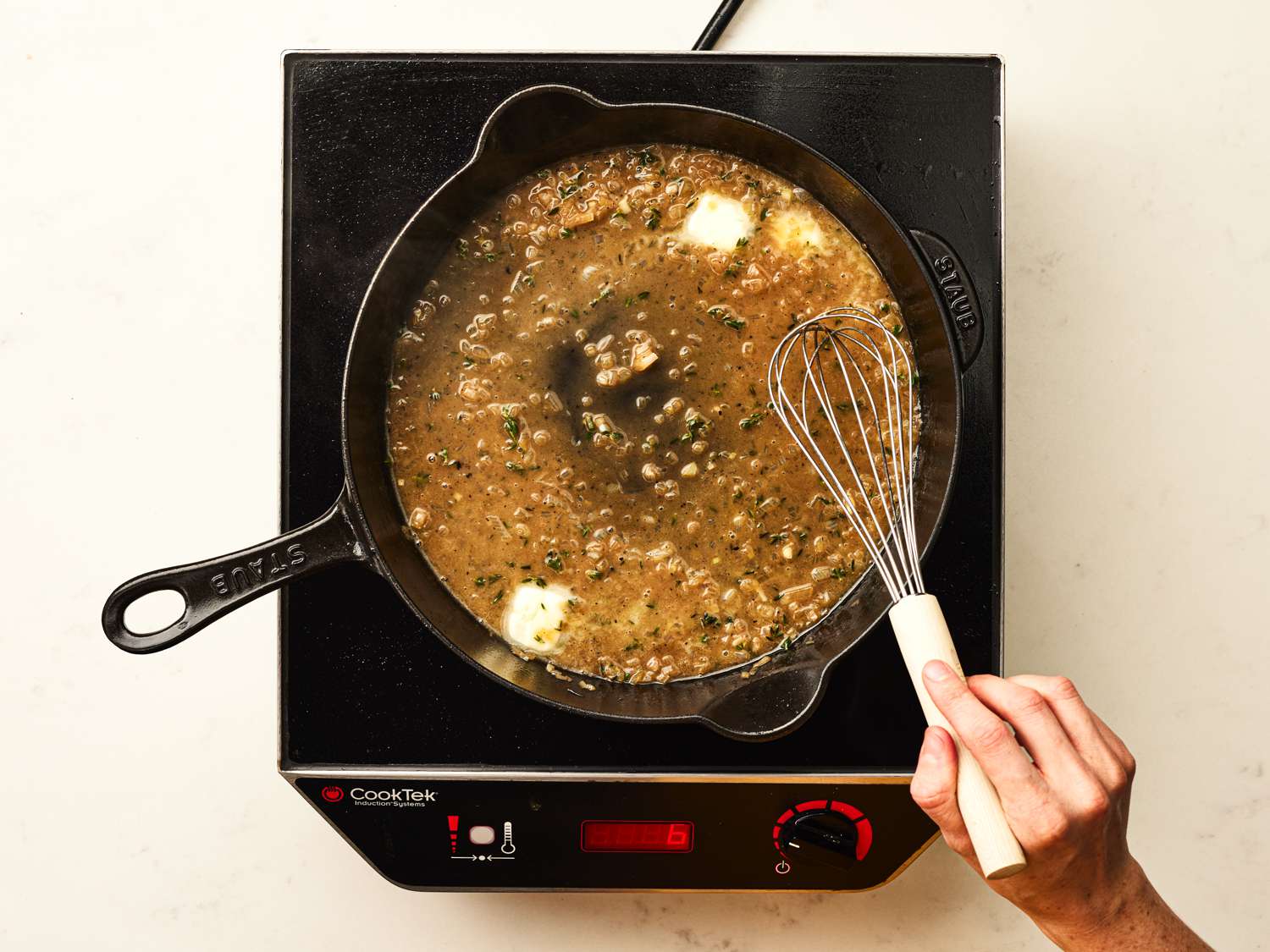 Whisking sauce in iron skiller