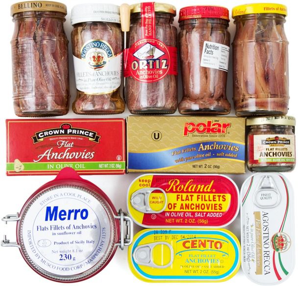 An assortment of cans and jars of anchovies. 