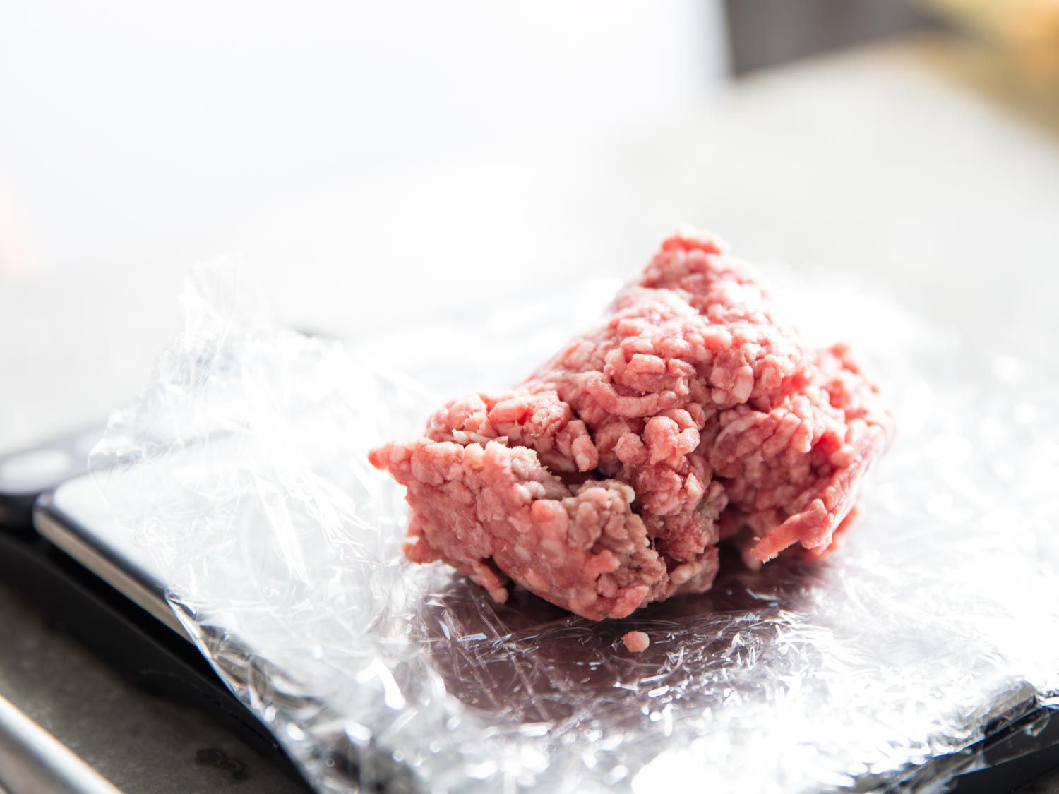 A mound of ground beef on plastic wrap 