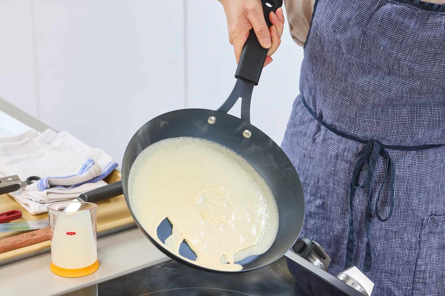 Crepe batter being swirled in the OXO Obsidian 10 Inch Pre-Seasoned Carbon Steel Frying Pan