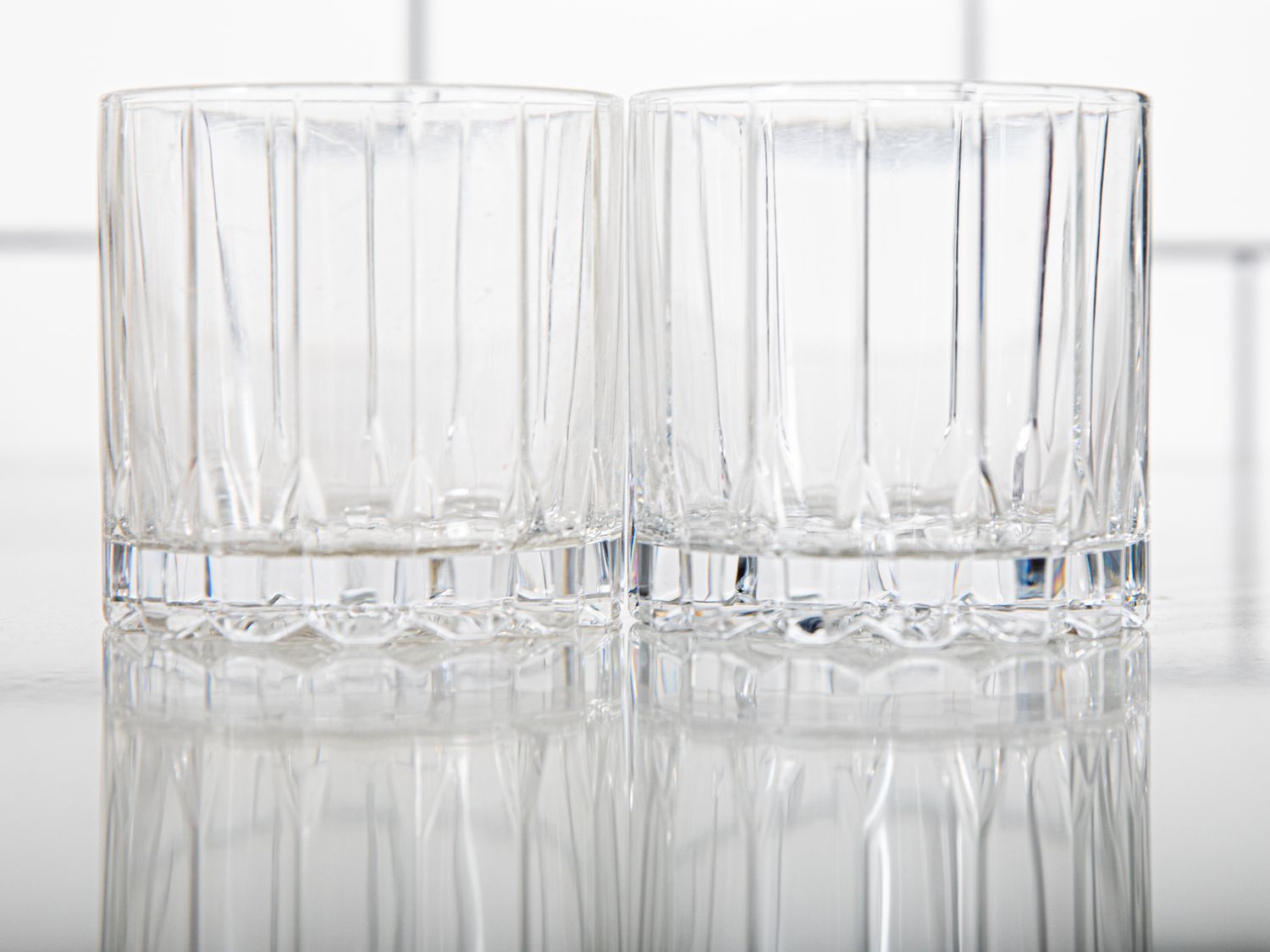 two whiskey glasses on a kitchen countertop
