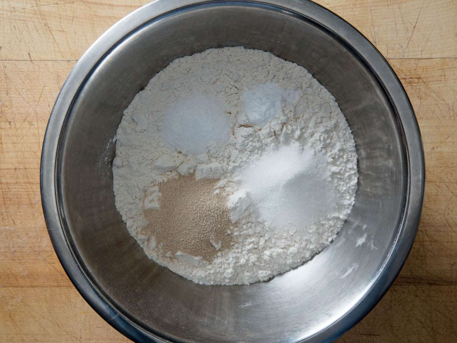 The dry ingredients for angel biscuits are added to a mixing bowl.