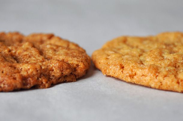 A side-by-side horizontal shot of a cookie made with dark brown sugar next to a cookie made with light brown sugar.