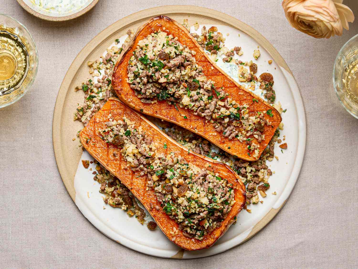 Two roasted squash halves stuffed with couscous and spices on a serving plate