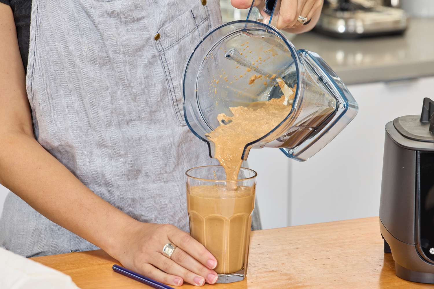 A person pouring items out of the Vitamix Ascent X5 Blender into a cup