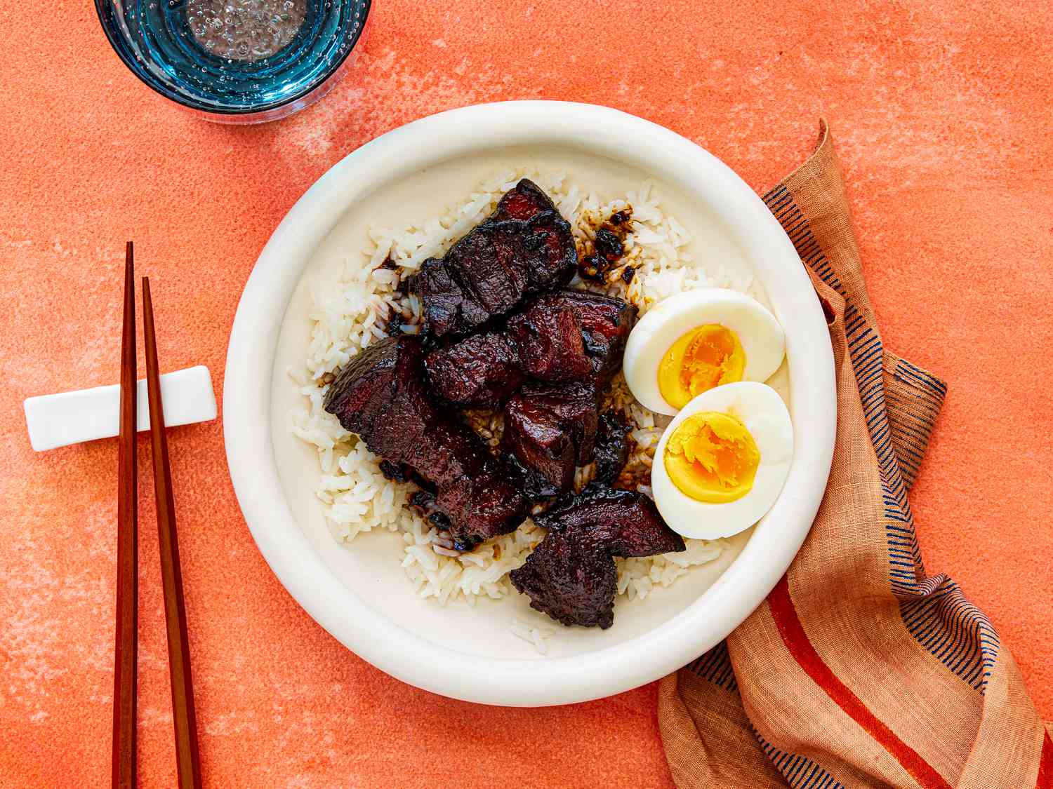 Overhead view of lu rou fan in a bowl with a boiled egg cut in half.