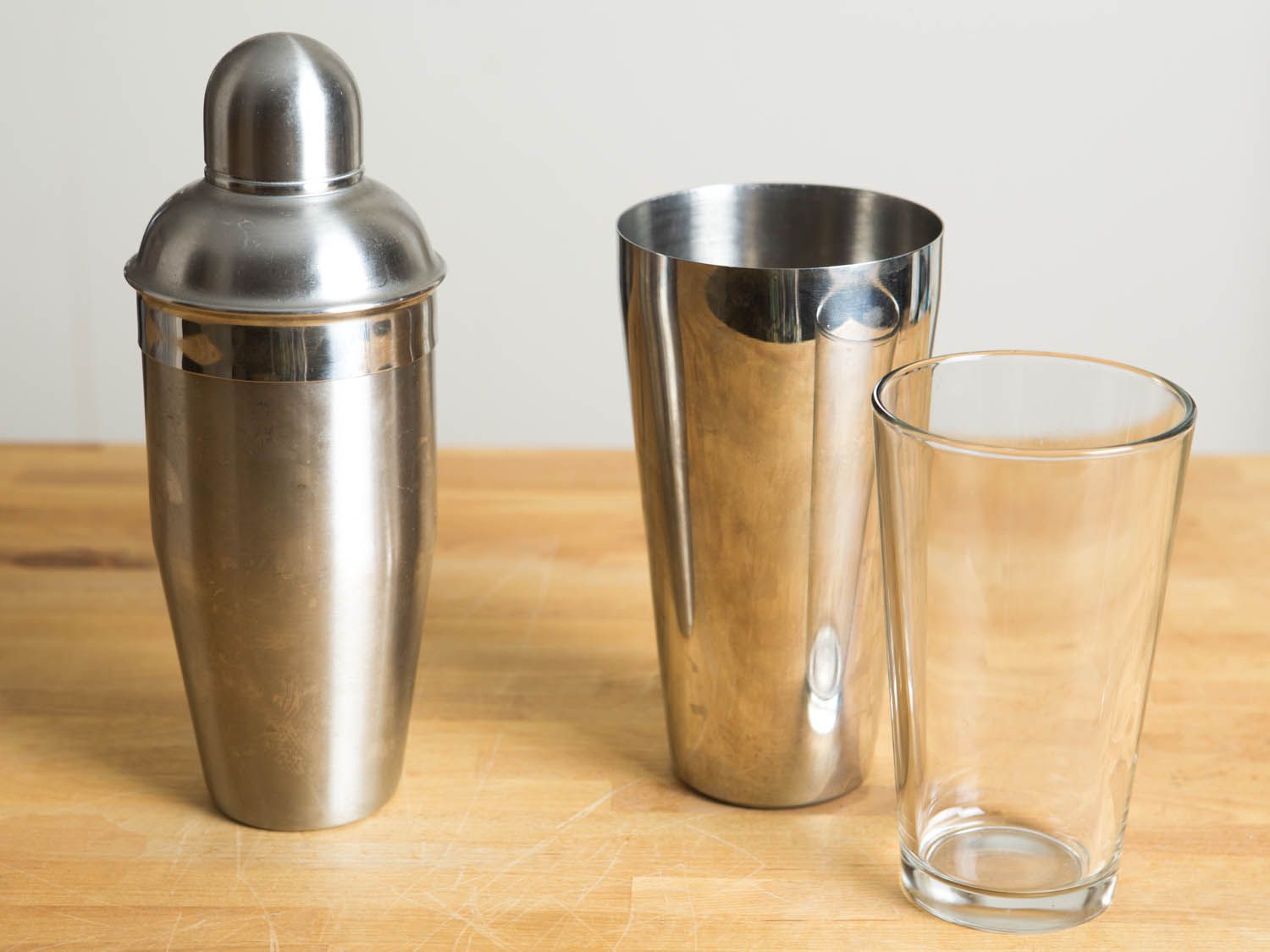 two cocktail shakers on a wooden surface