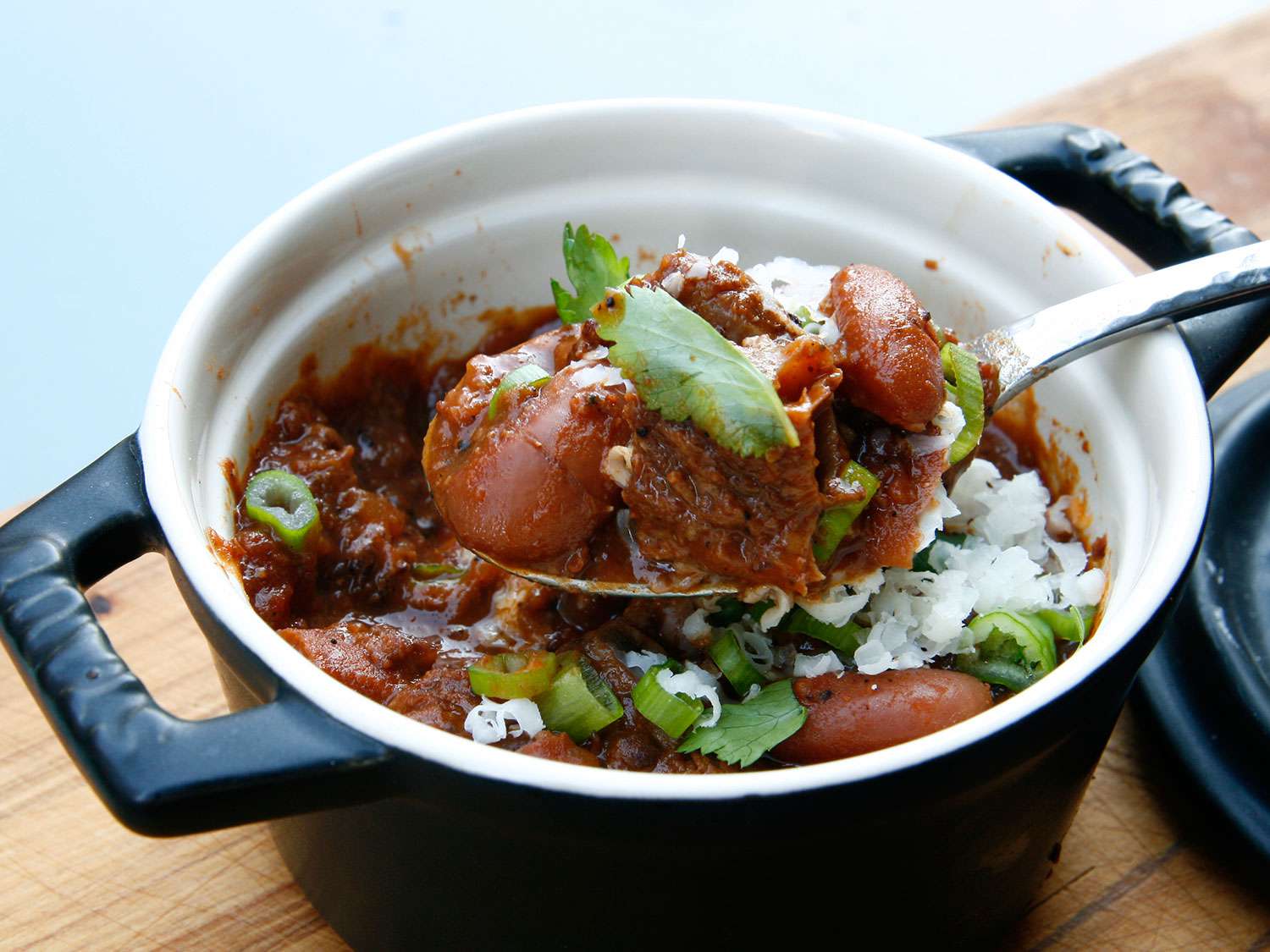 Closeup of Oklahoma-style chili, served in an enameled cast iron cocotte.