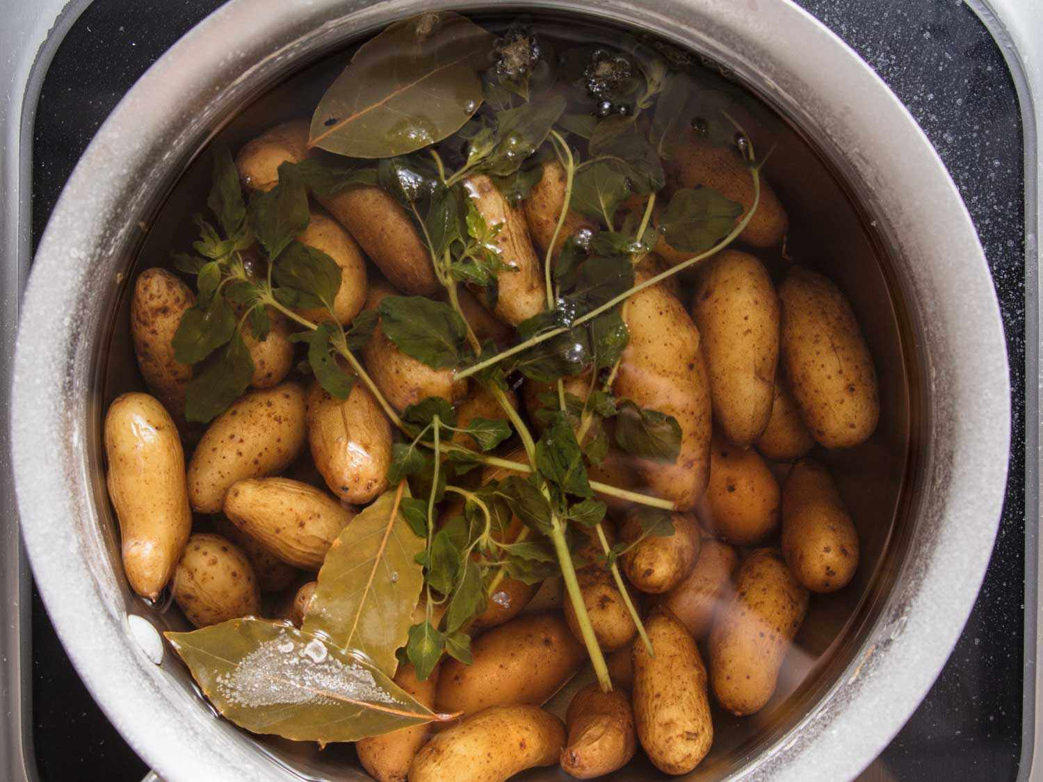 Fingerling potatoes simmered in salt water with aromatics.