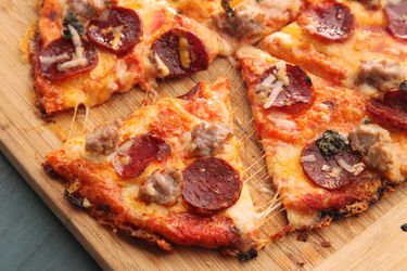 A pepperoni quesadilla pizza cut into wedges on a wooden board