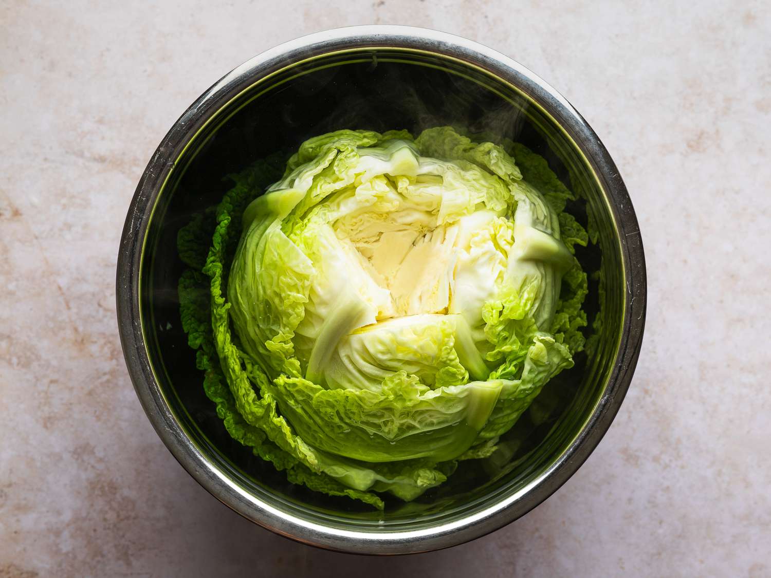 Cabbage covered in boiling water in a large heatproof bowl.