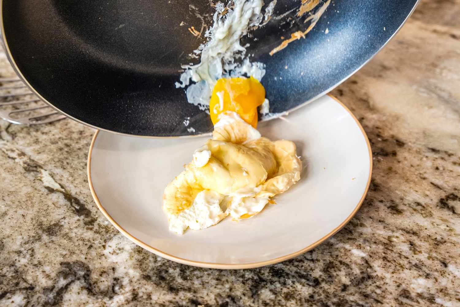 An egg sticking to a black nonstick slo;;et