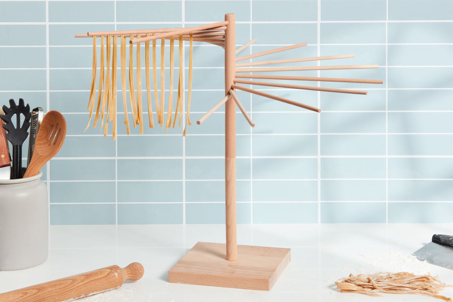 Sänger Wooden Pasta Dryer draped with noodles displayed on white kitchen counter