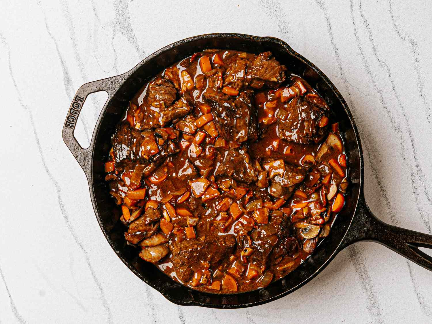 Beef bourguignon in a cast iron skillet on a countertop