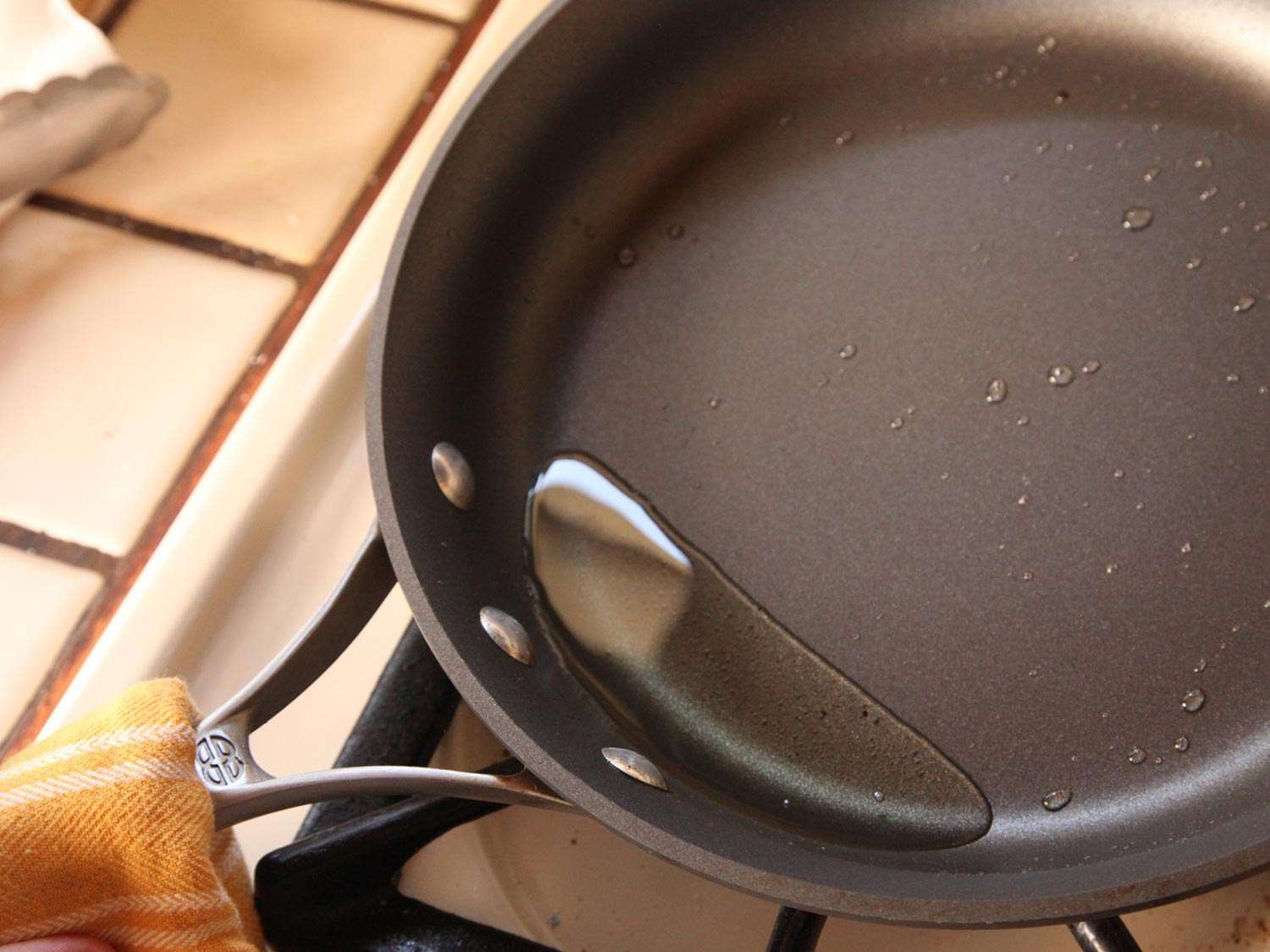 Heating a non-stick pan with oil in it and tilting the pan to fry eggs for huevos rancheros