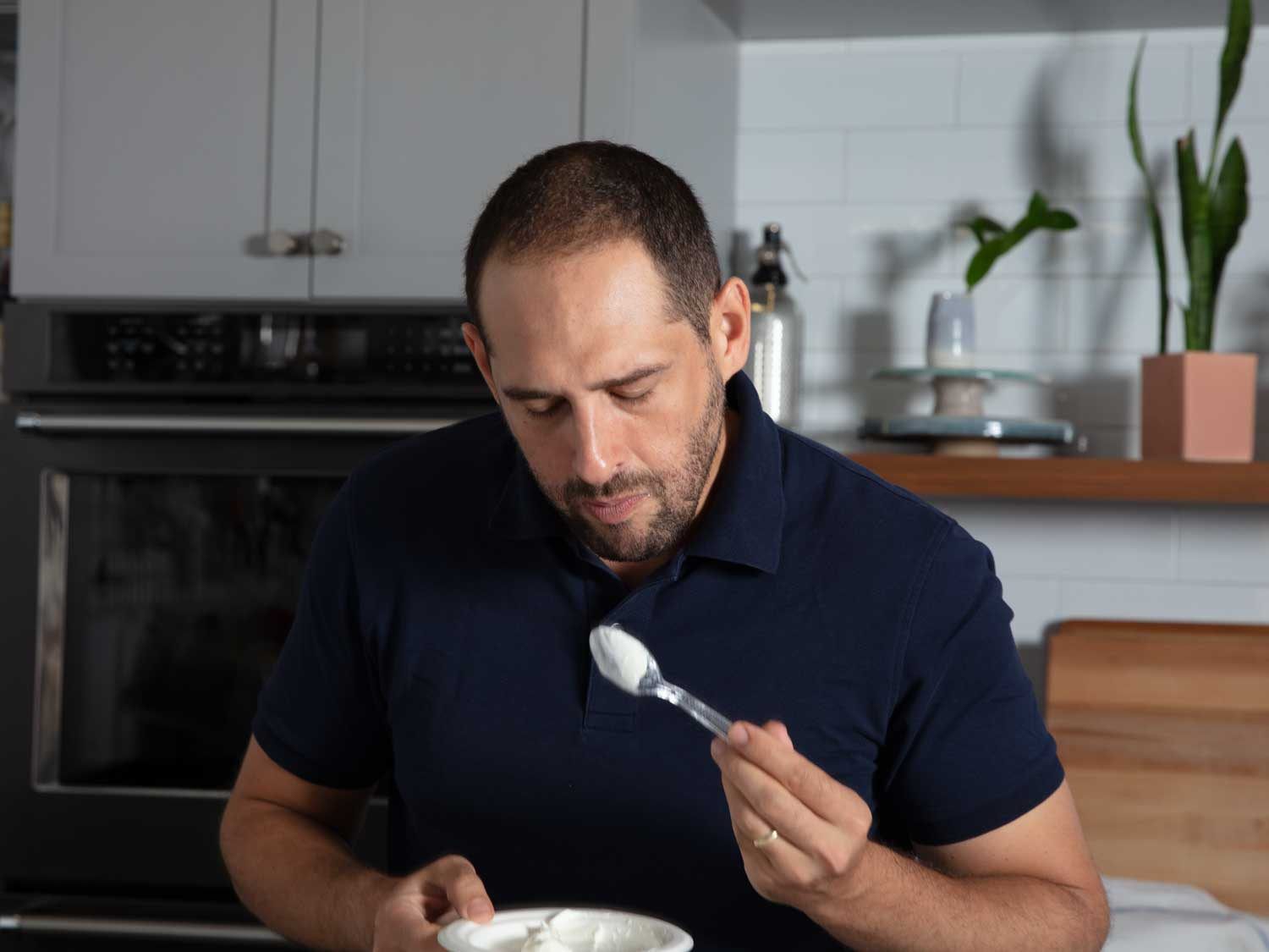 Daniel inspects a spoonful of Greek yogurt.