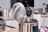 The Instant Pot Duo Plus 8 Quart Multi-Use Pressure Cooker with the lid off and resting on the handle