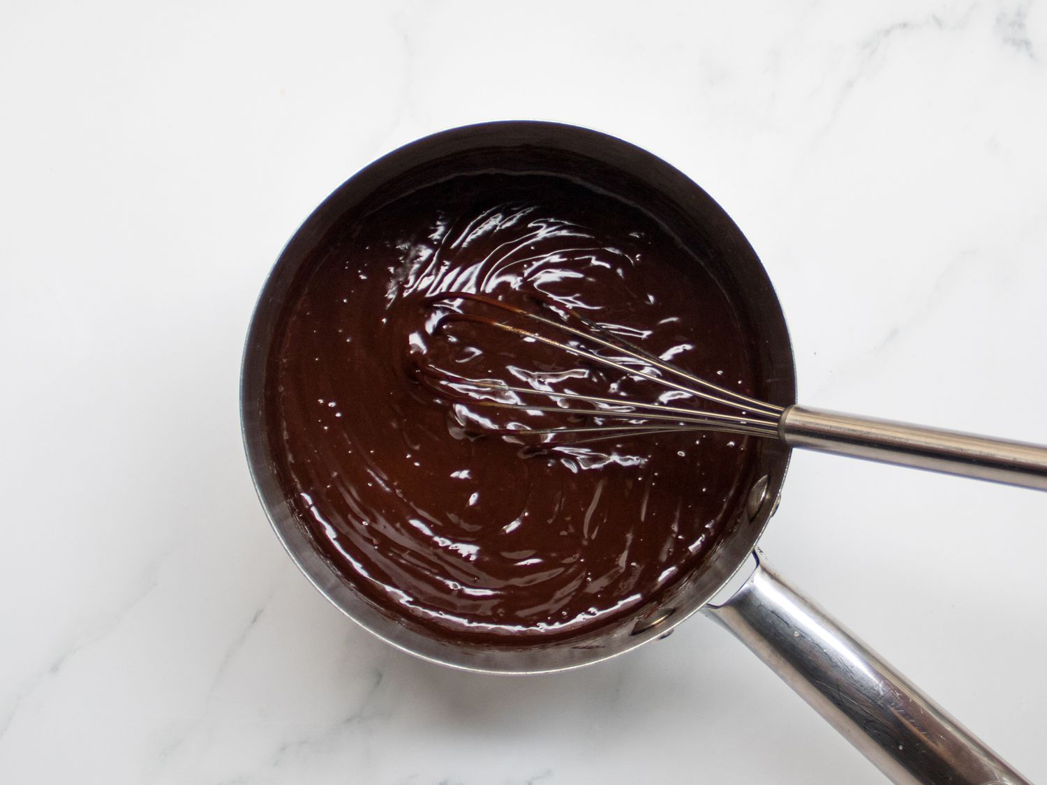 Whisking chocolate in a pot until smooth