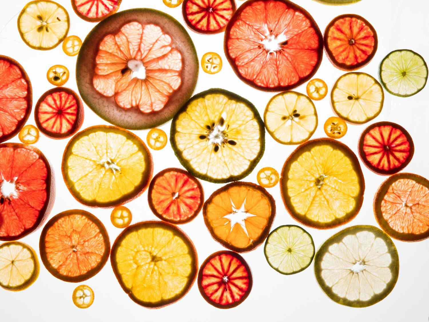 Thinly sliced citrus wheels on a well-lit board, so they appear translucent.