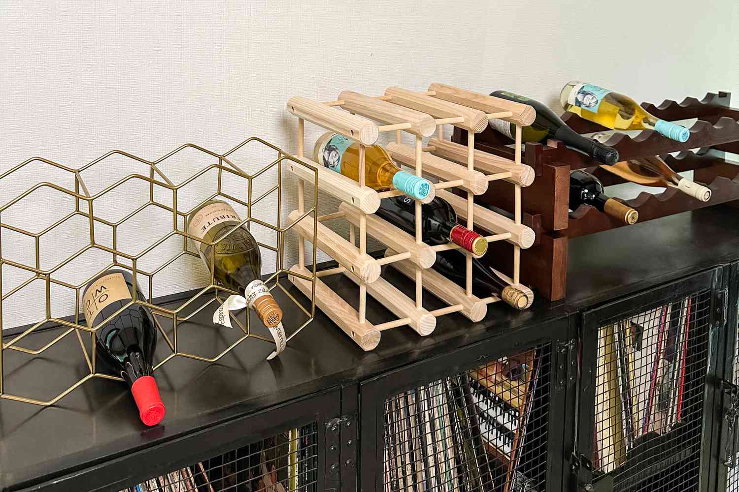Three wine racks sitting on top of a cabinet.