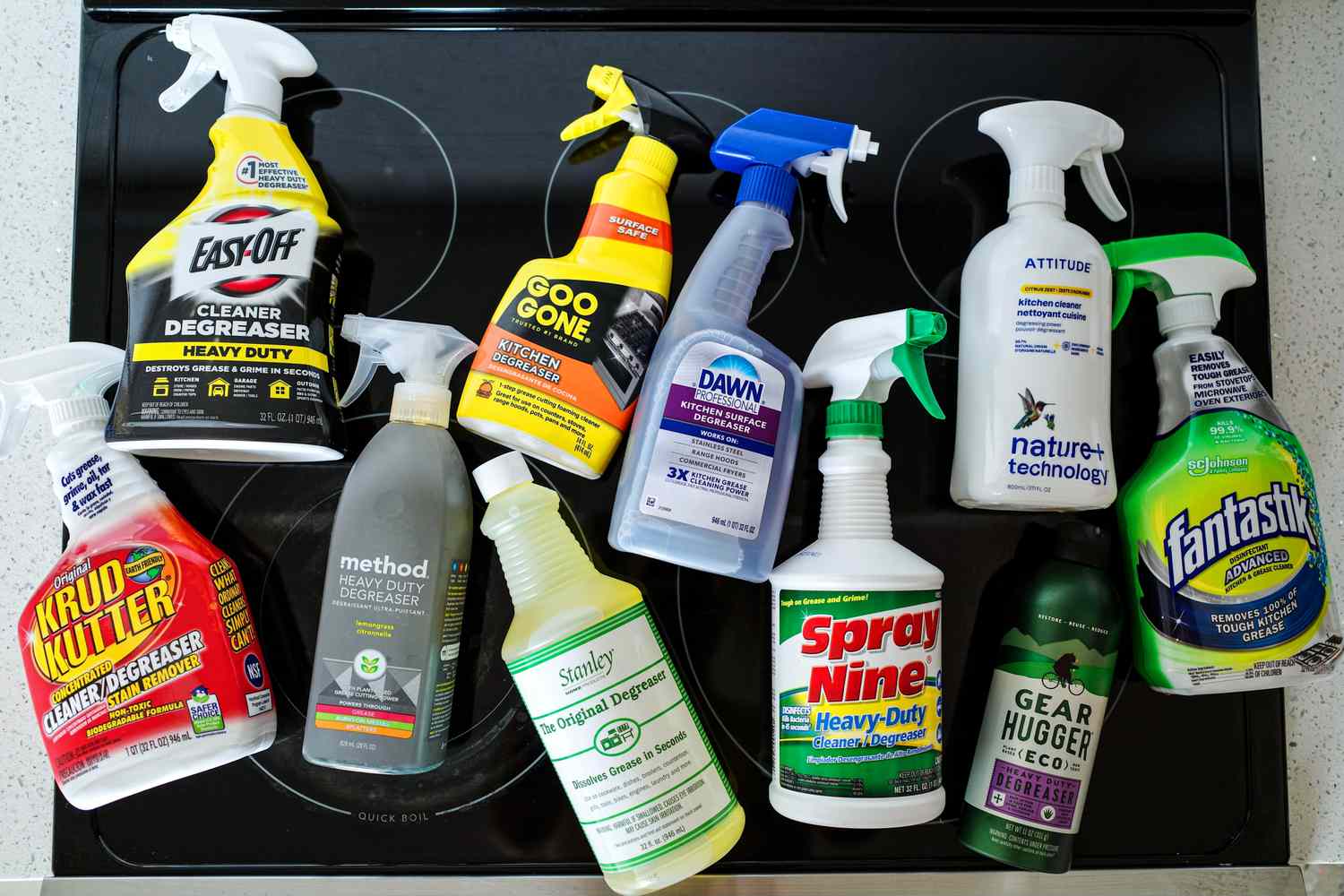 A collection of degreasers on a glass stovetop