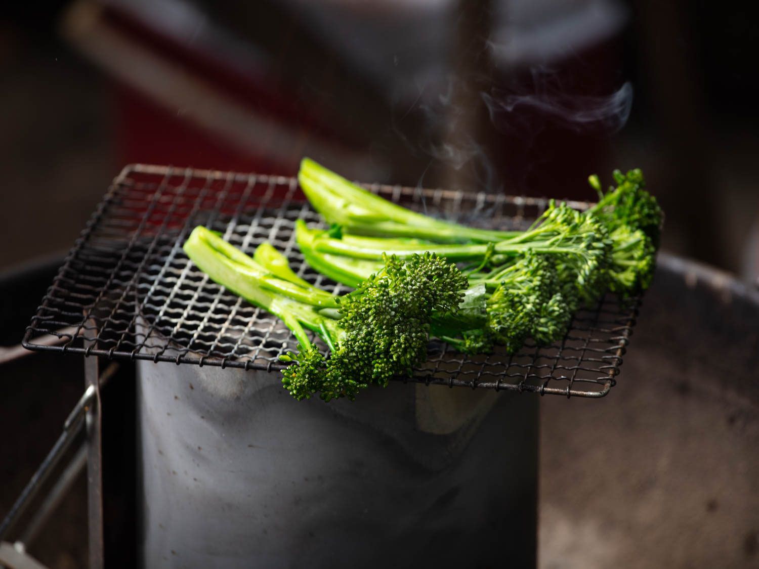Grilling broccolini over a chimney starter.