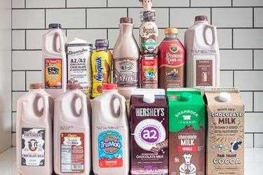 A variety of chocolate milk brands displayed on a counter including cartons and bottles