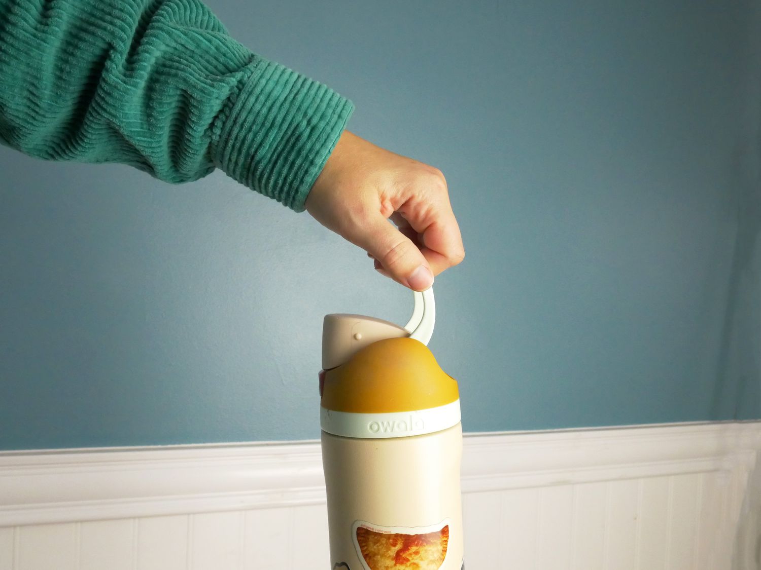 a person holding the owala water bottle by the locking lid