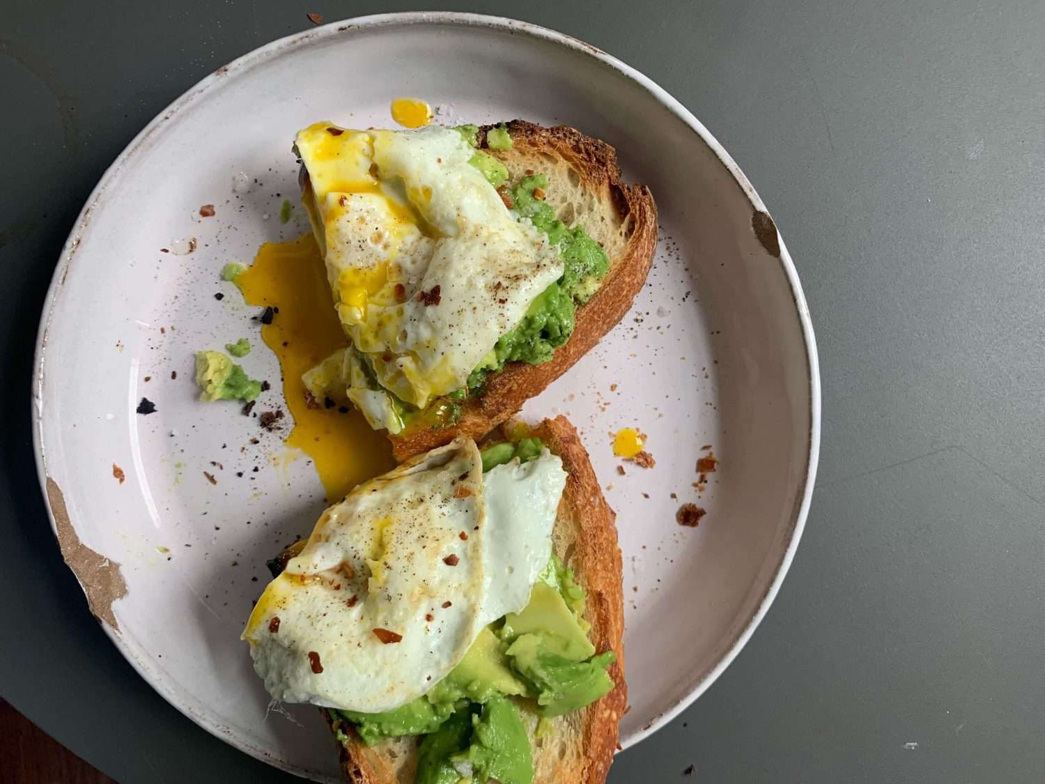 Overhead view of toast with avocado and a fried egg